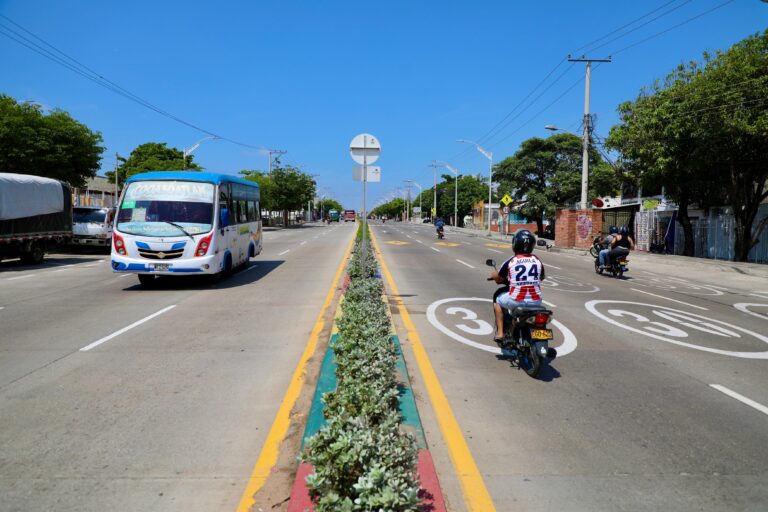 Separador central La Cordialidad con tránsito de una moto y un bus en ambos sentidos
