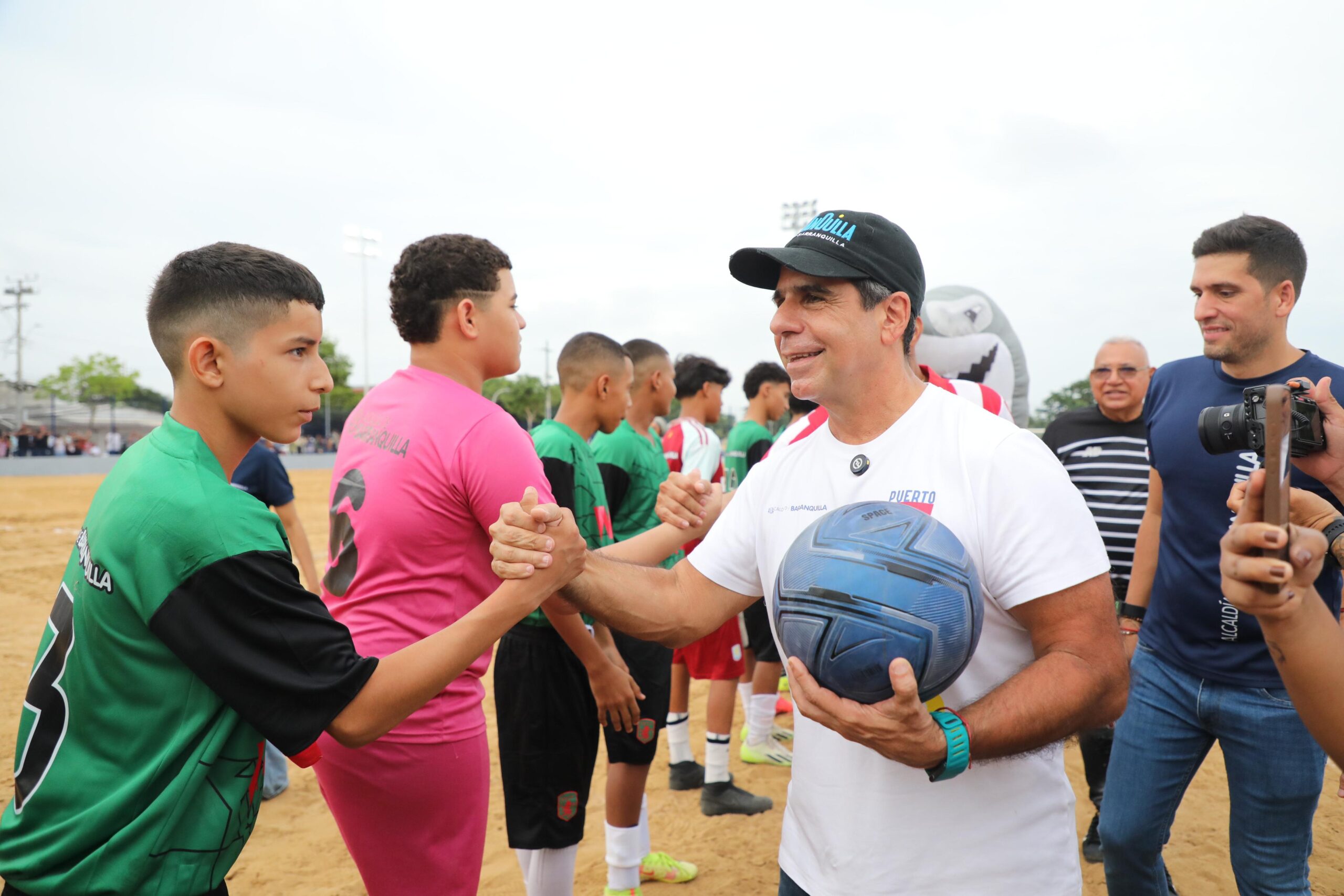 Alcalde Char estrecha la mano de un joven futbolista en la cancha de arena del polideportivo La Magdalena.