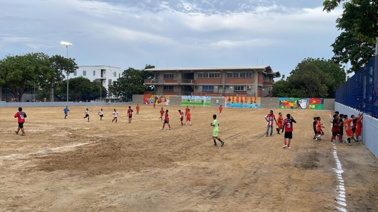 Grupo de niños jugando en cancha de arena en el polideportivo La Magdalena.