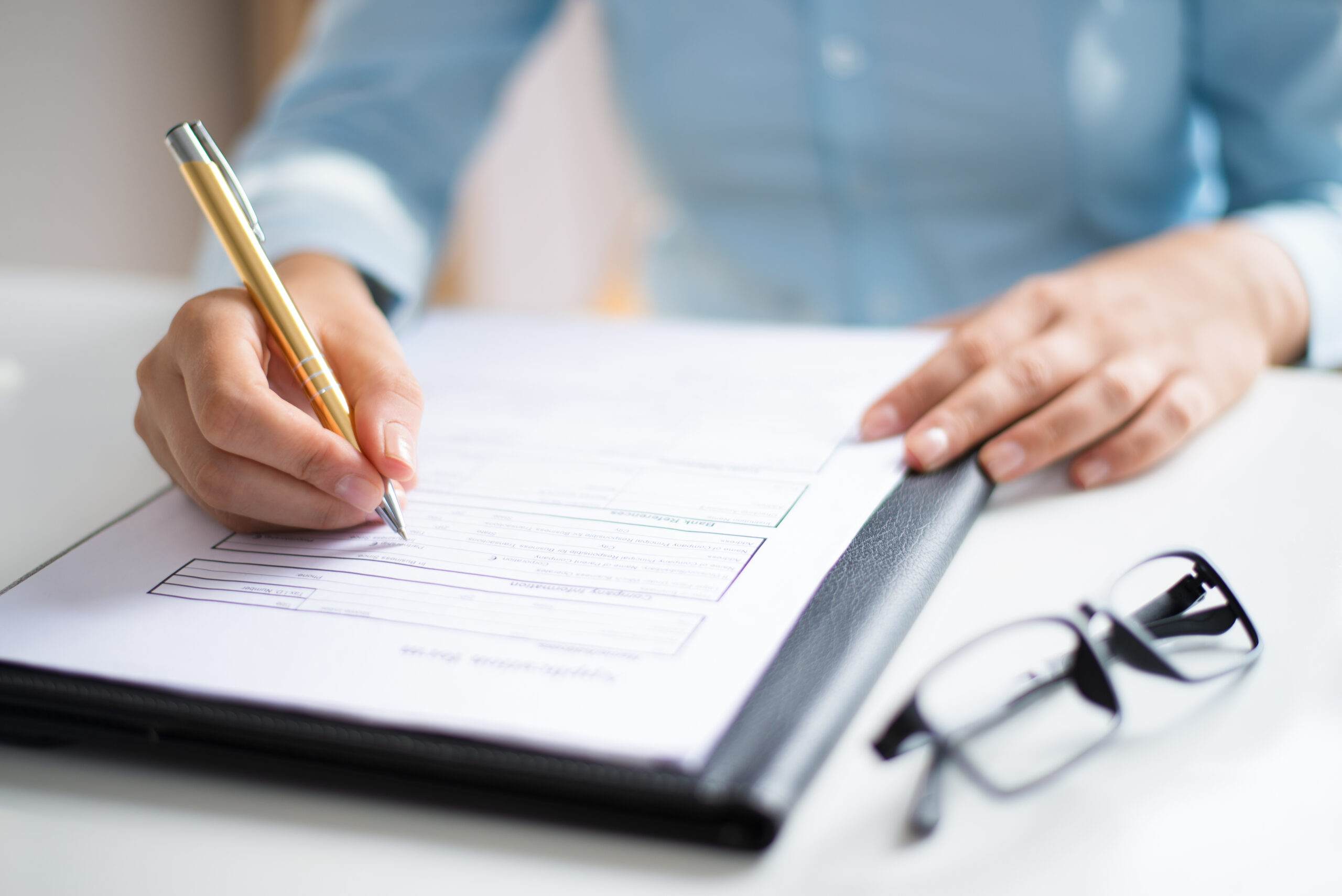 Primer plano de una persona firmando un documento.