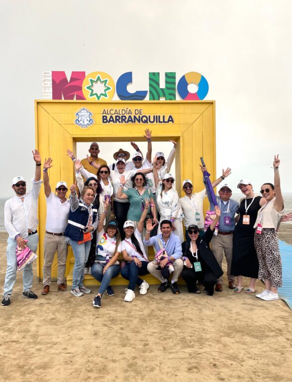 Grupo de personas posando en letrero de la playa de Puerto Mocho.