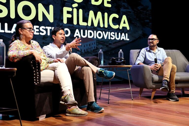 Panelistas sentados conversan durante foro sobre producción fílmica y desarrollo audiovisual.