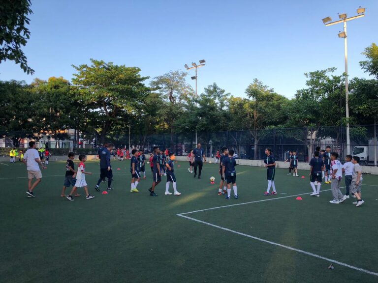Jóvenes en prácticas de fútbol en una cancha deportiva