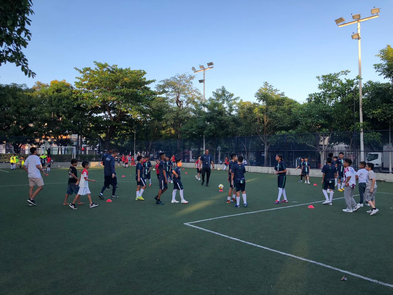 Jóvenes en prácticas de fútbol en una cancha deportiva