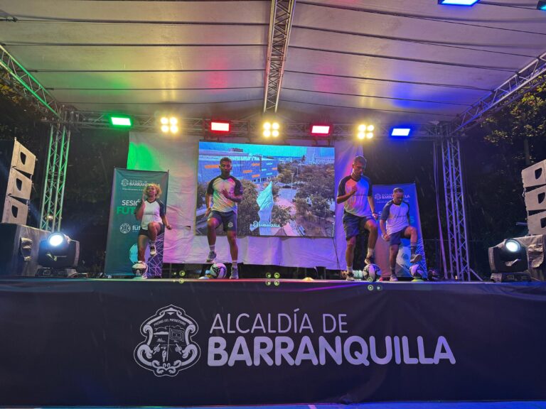 Instructores realizan ejercicios aeróbicos sobre tarima durante jornada nocturna de actividad física en Barranquilla.