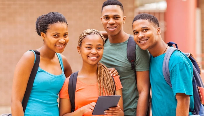 Grupo de jóvenes posan sonriendo en primer plano.