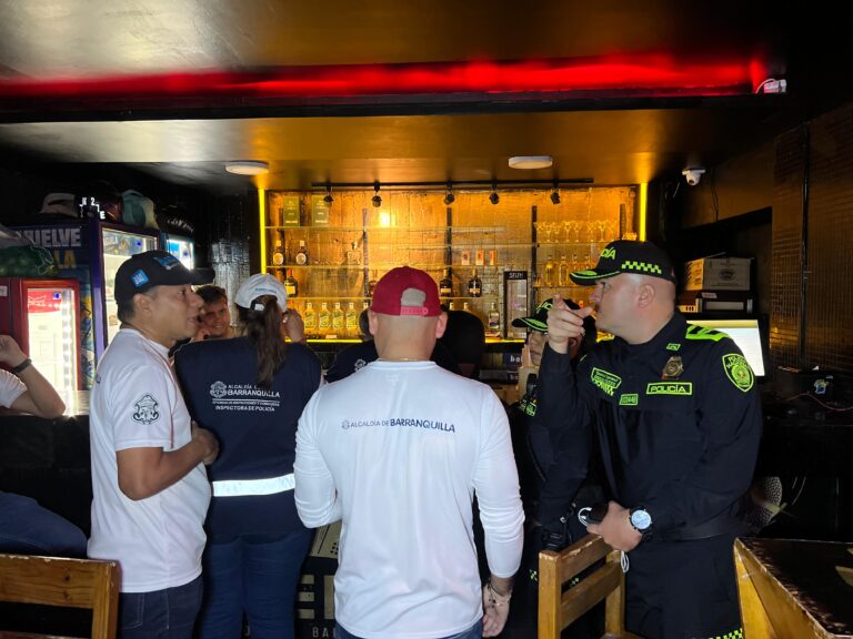 Grupo de funcionarios y fuerza pública en establecimiento de comercio en operativo para la prevención y control de delitos.