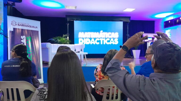 Personas en auditorio ven en pantalla nombre del programa