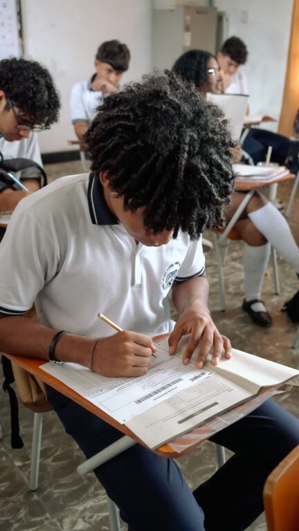 Estudiante presenta prueba escrita en el aula de clases.