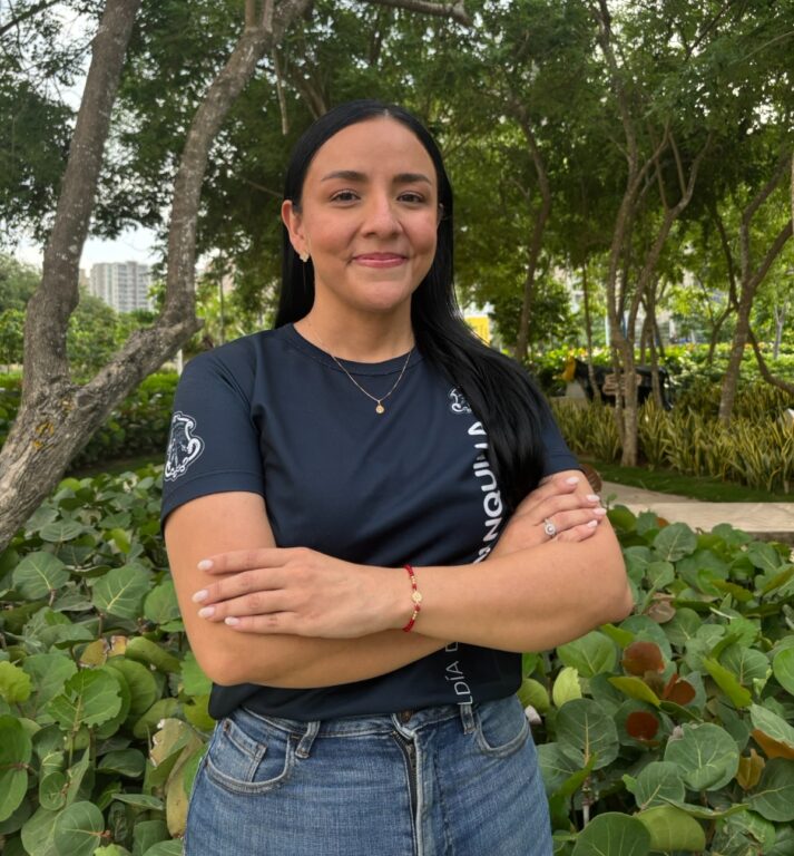 Funcionaria Sugey Correa, en plano medio con camiseta institucional azul y de brazos cruzados al nivel de la cintura.