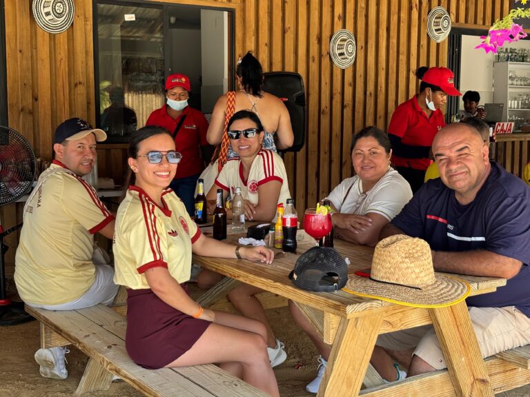 Grupo de aficionados con camisetas de la Selección Colombia comparte bebidas en un restaurante en la playa de Puerto Mocho.
