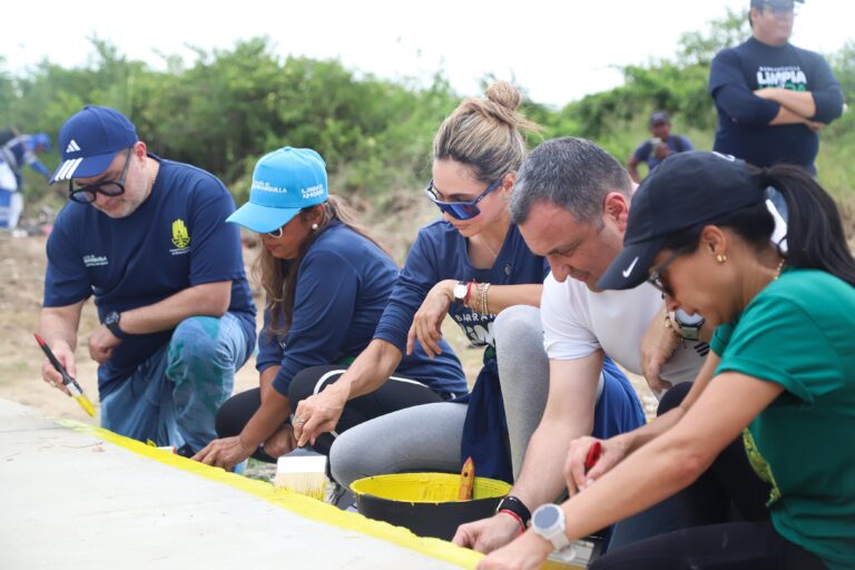 Ana María Aljure, Yesid Turbay y otros participantes pintando los andenes como parte de la iniciativa Barranquilla Limpia y Linda.