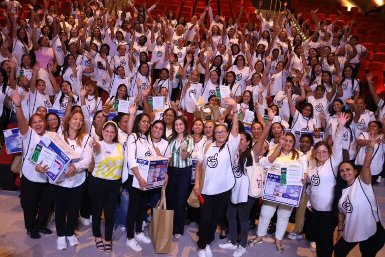 María Eugenia Yunis y Katia Nule junto a beneficiarias del programa De la Mano con la Primera, sonríen con manos alzadas.