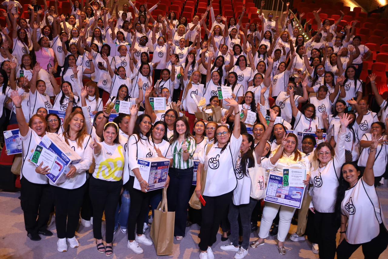 María Eugenia Yunis y Katia Nule junto a beneficiarias del programa De la Mano con la Primera, sonríen con manos alzadas.