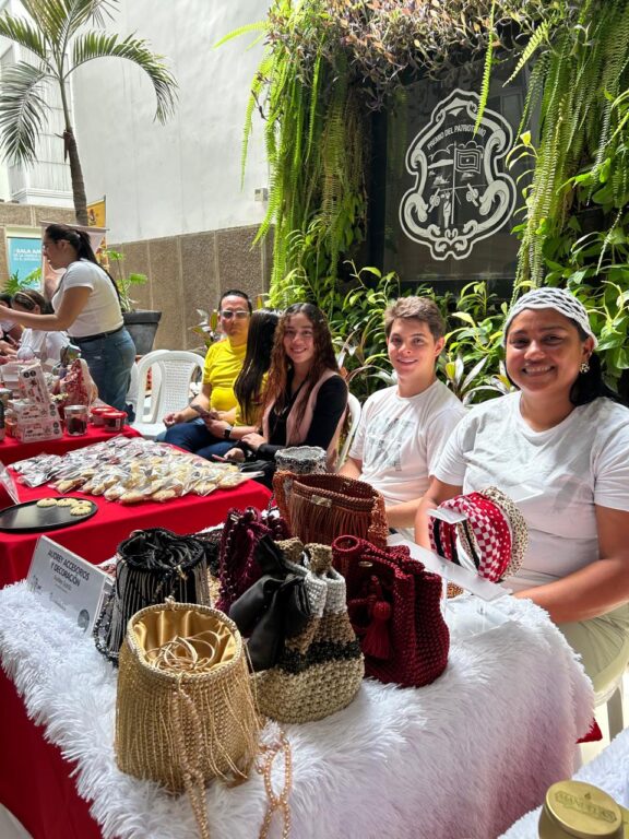 Funcionarios posan frente a sus emprendimientos en feria.