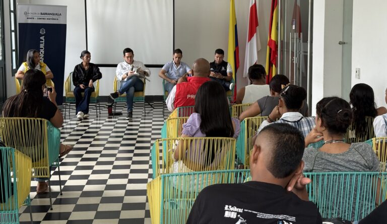 Alcalde local junto a representantes. El salón está lleno de votantes víctimas del conflicto armado