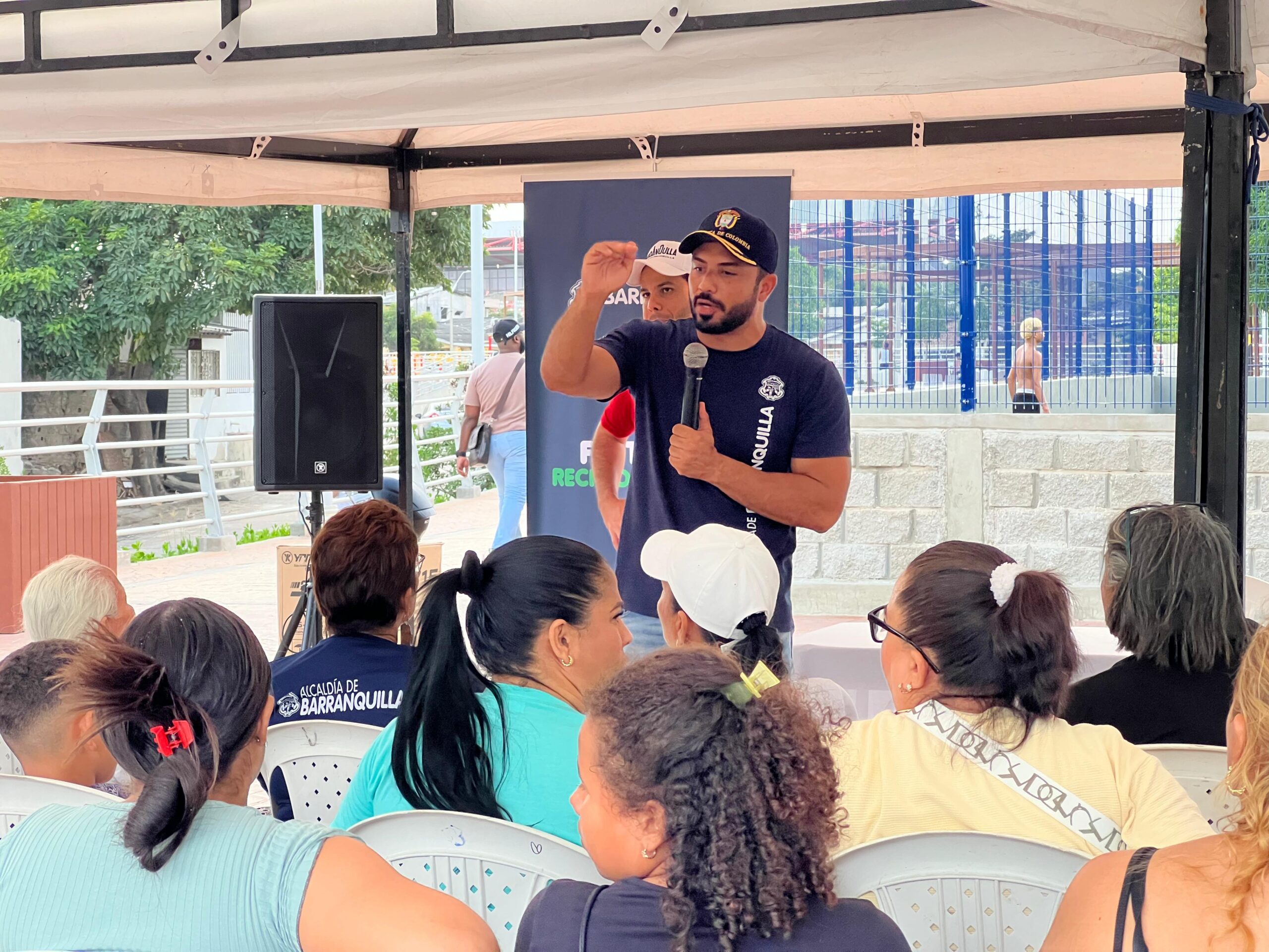 Funcionario del Distrito hablando frente a la comunidad.