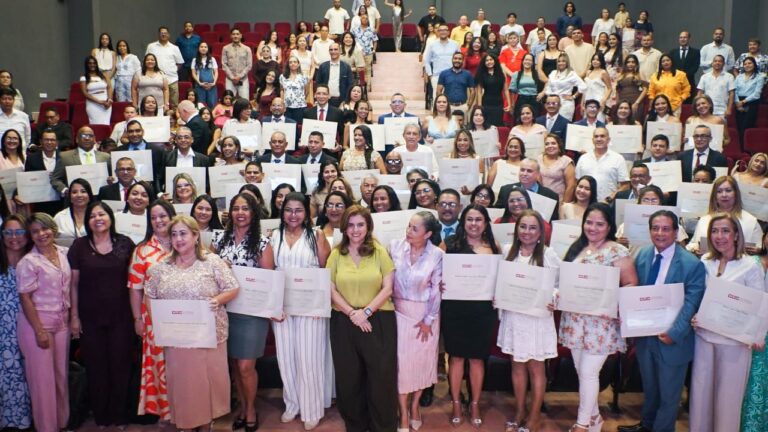 Secretaria de Educación junto grupo de docentes con su diploma de magíster