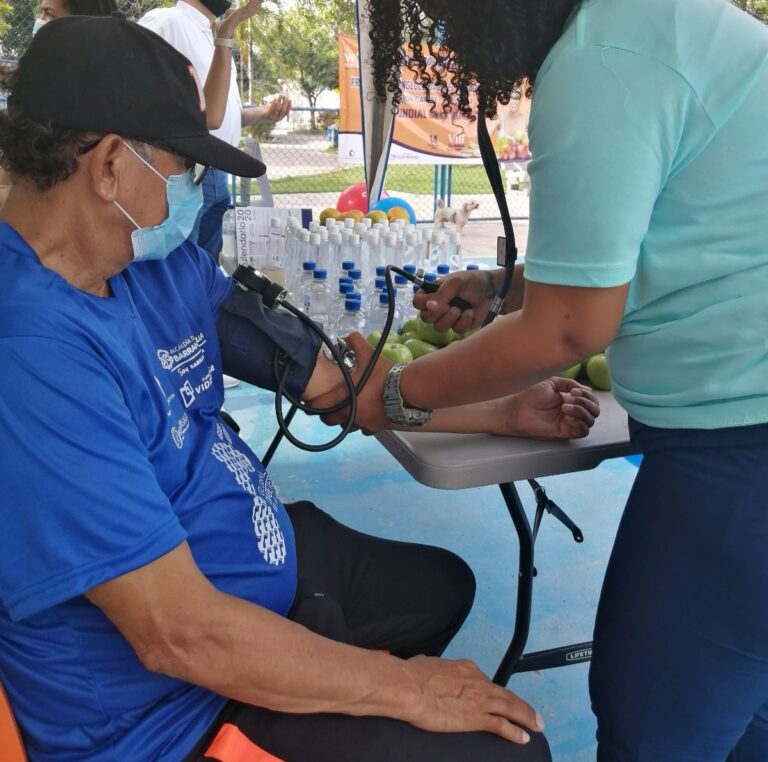 Profesional de la salud toma la presión arterial a un hombre durante brigada de salud.