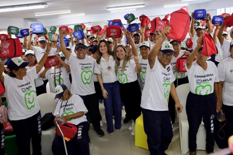 Adultos mayores sonrientes levantan kits de salud oral durante el lanzamiento del proyecto en Barranquilla, junto a Katia Nule, Ismael Marín y Vianet Niebles.