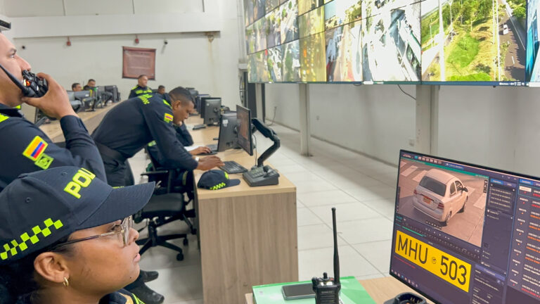 Agentes de policía monitorean cámaras de seguridad en centro de control, observando imágenes en tiempo real.
