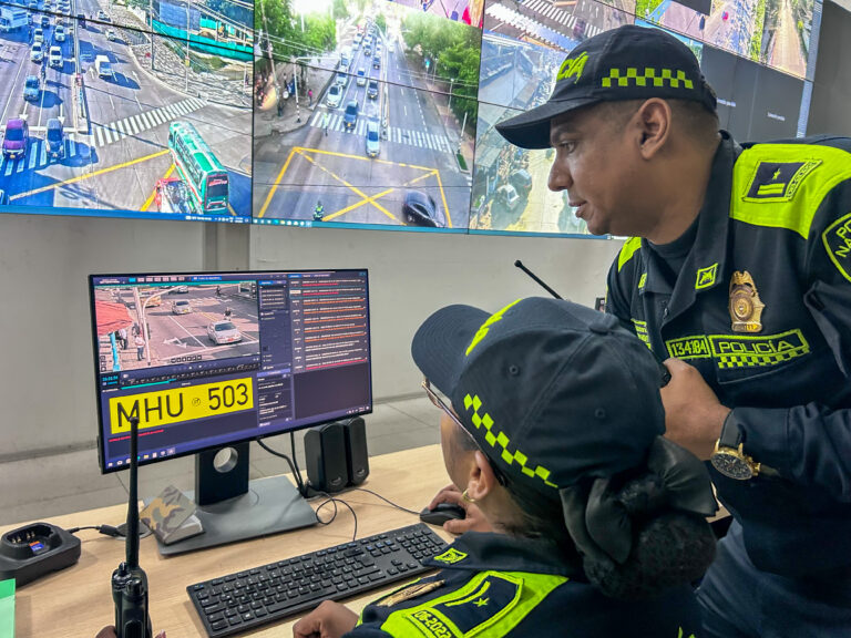 Agentes de policía monitorean cámaras de seguridad en centro de control, observando imágenes en tiempo real.