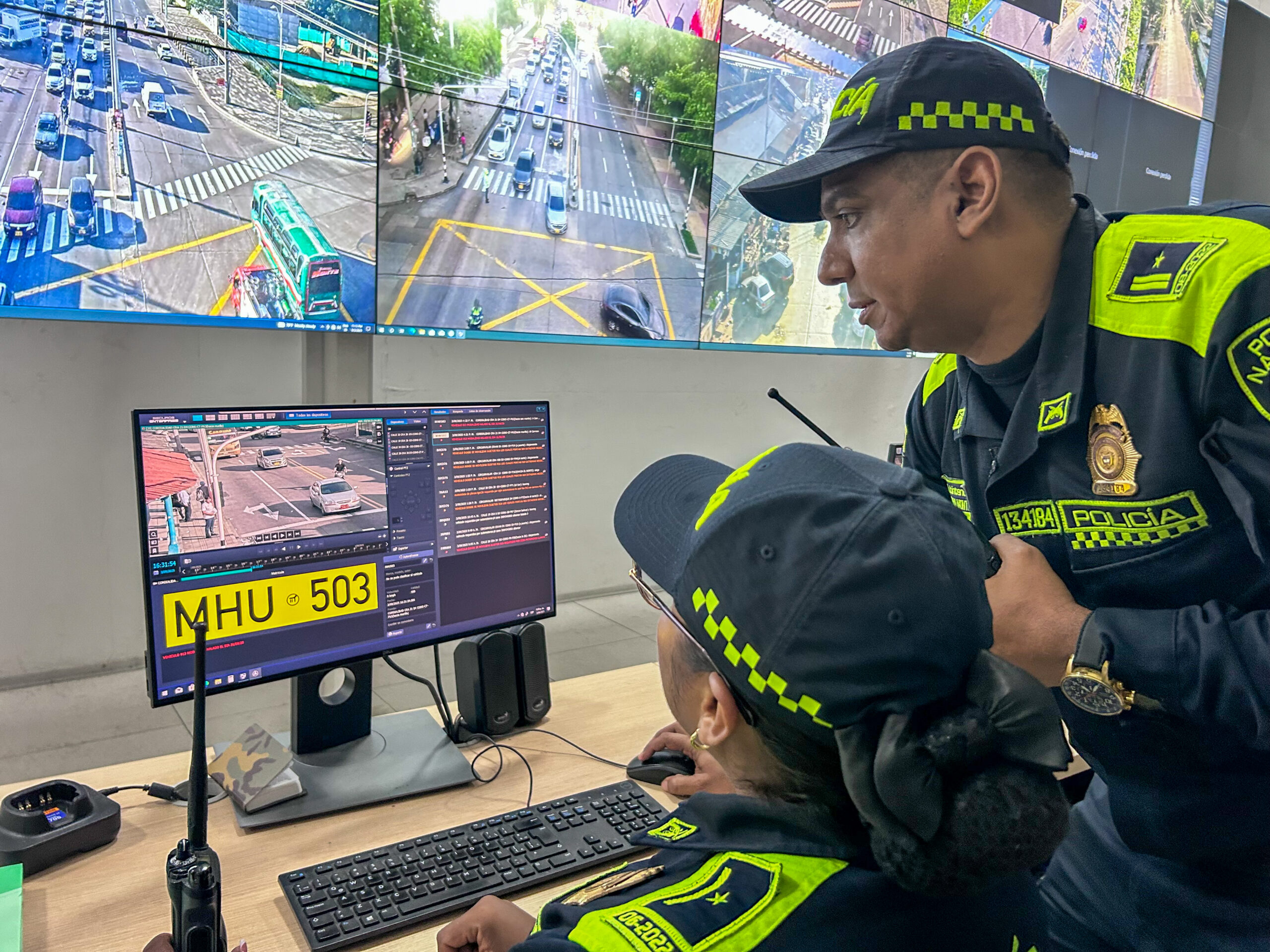 Agentes de policía monitorean cámaras de seguridad en centro de control, observando imágenes en tiempo real.