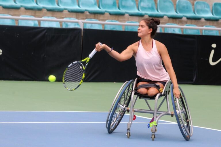 Mujer paralímpica jugando tenis en s silla de ruedas