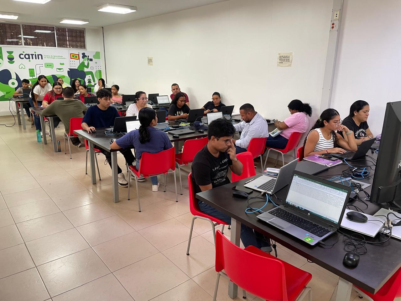 Distrito abre nueva oferta de cursos gratuitos en los CATIN Personas recibiendo clases en computadores.