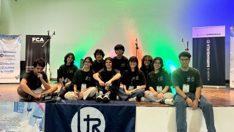 Grupo de jóvenes estudiantes sentados en una pequeña tarima