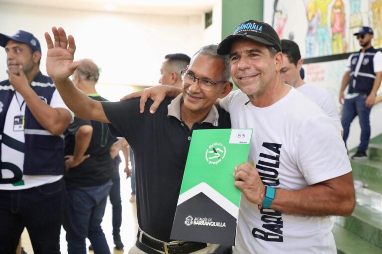 Alcalde abrazando a beneficiario de titulo de propiedad