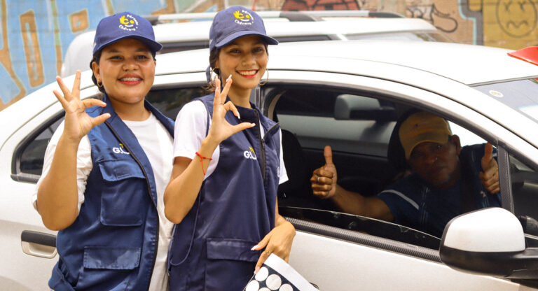 Guías cívicos hablando con ciudadano en vehículo particular