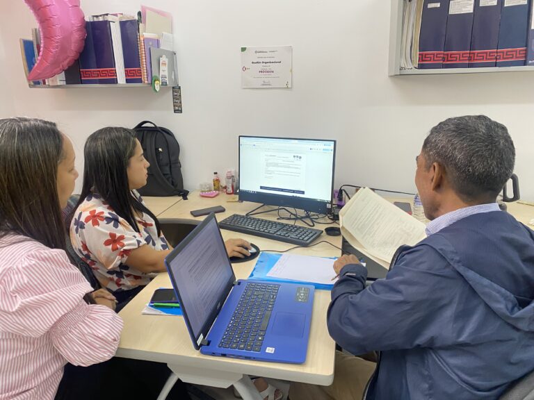 agentes de cambio sentadas frente a computador mostrando documentación a auditor