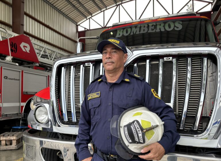 Comandante del Cuerpo oficial de bomberos, posa junto al carro de bombero.