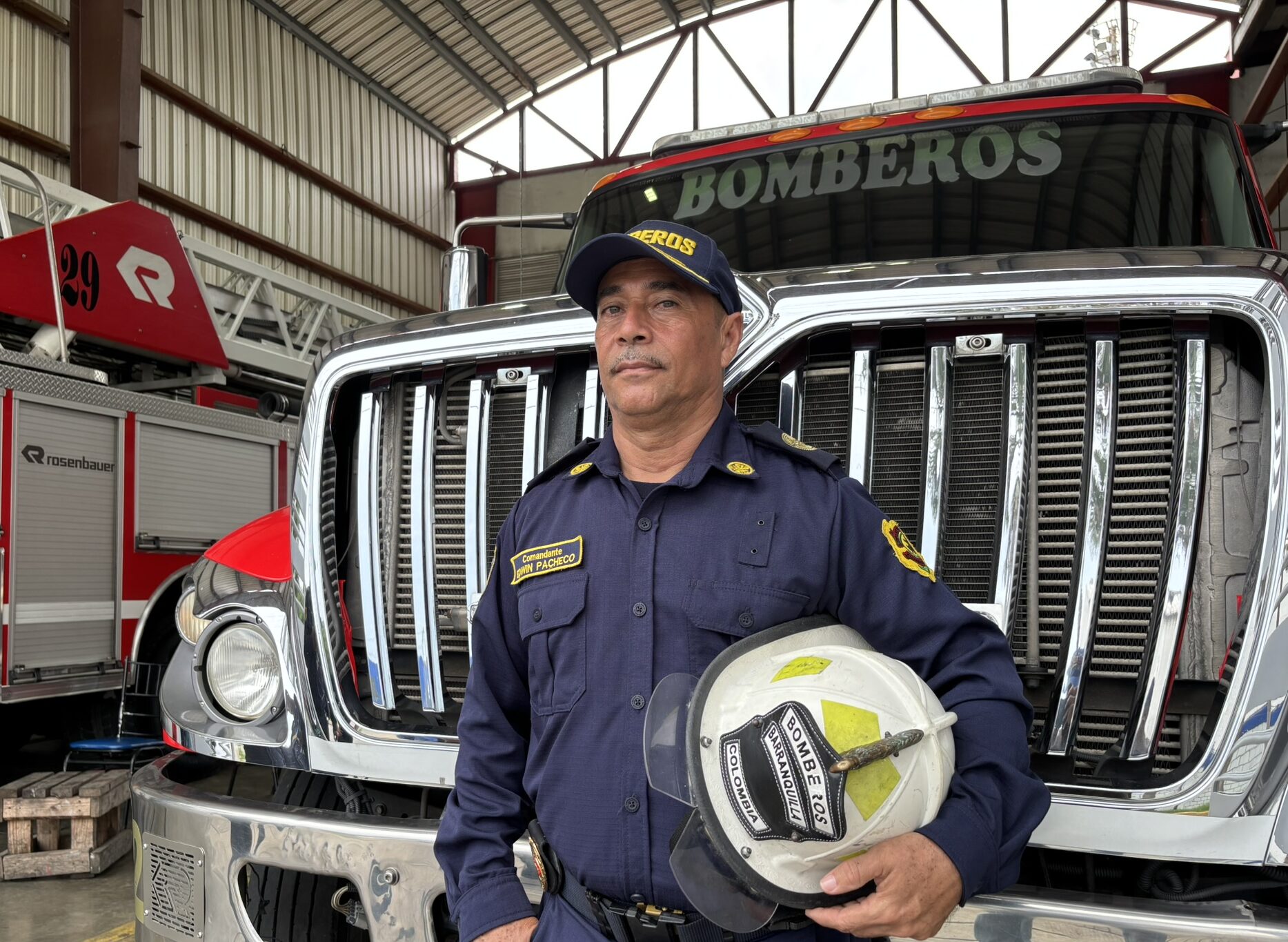 Edwin Álvaro Pacheco Ruiz Comandante del Cuerpo oficial de bomberos, posa junto al carro de bombero.