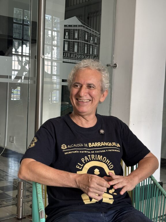 Alirio sentado sonriendo en medio de una entrevista .
