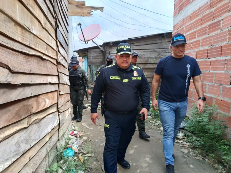 Policía y funcionario del Distrito caminando.