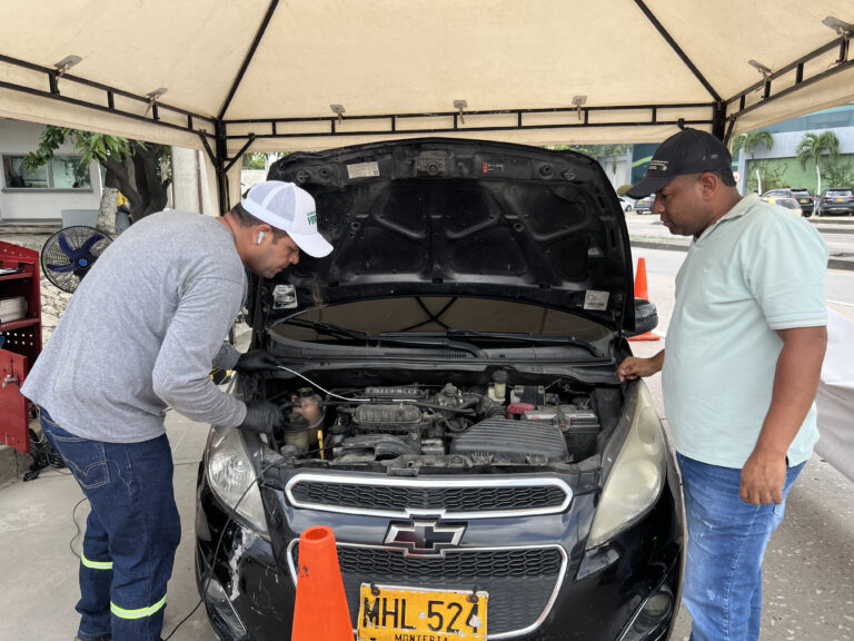 Dos hombres revisando el motor de un vehiculo