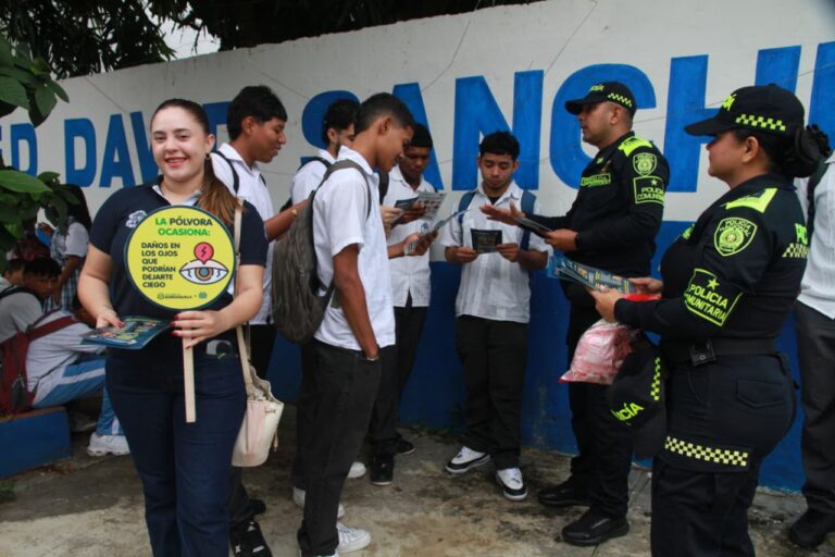 Funcionarios de la Policía entregando folletos a estudiantes de colegio.