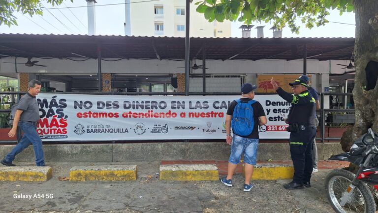 pasacalle con la frase no des en las calles con personas y un policía mirando
