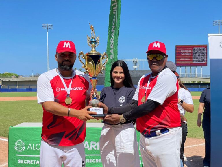 Funcionaria haciendo entrega de trofeo a jugadores del equipo campeón del Torneo Interbarrial de Béisbol