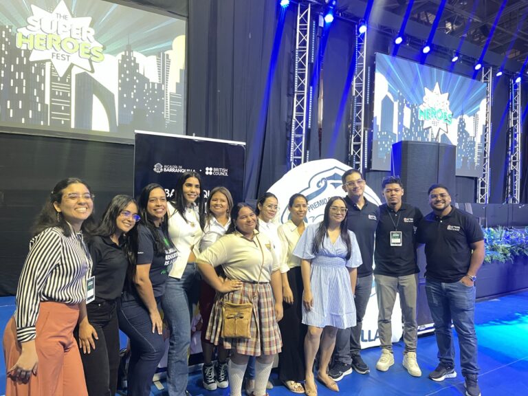 Grupo de estudiantes, docentes y funcionarios sobre escenario en el cierre ciclo formativo de bilingúismo