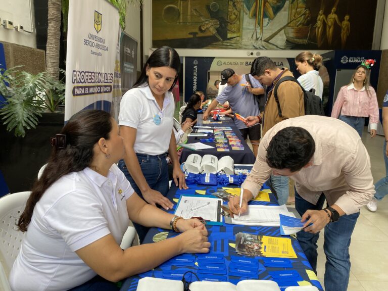 Asesores en stands explican sus servicios.