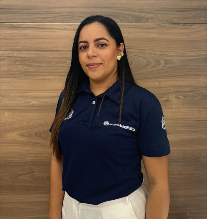 Funcionaria de pie en plano medio, sueter azul institucional