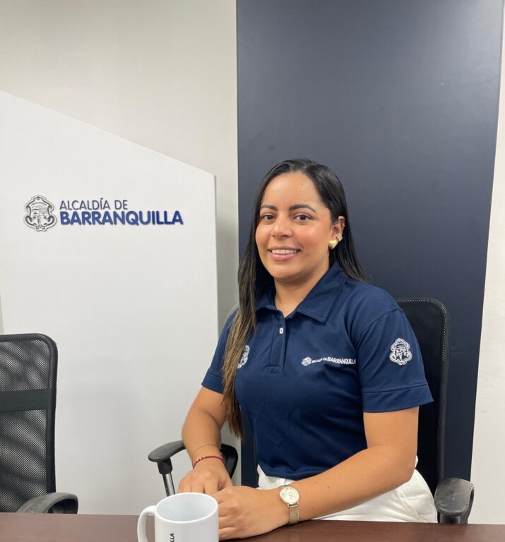 Funcionaria Sandra Gómez, en plano medios, posa sentada detrás de una mesa con las manos apoyadas sobre la mesa.