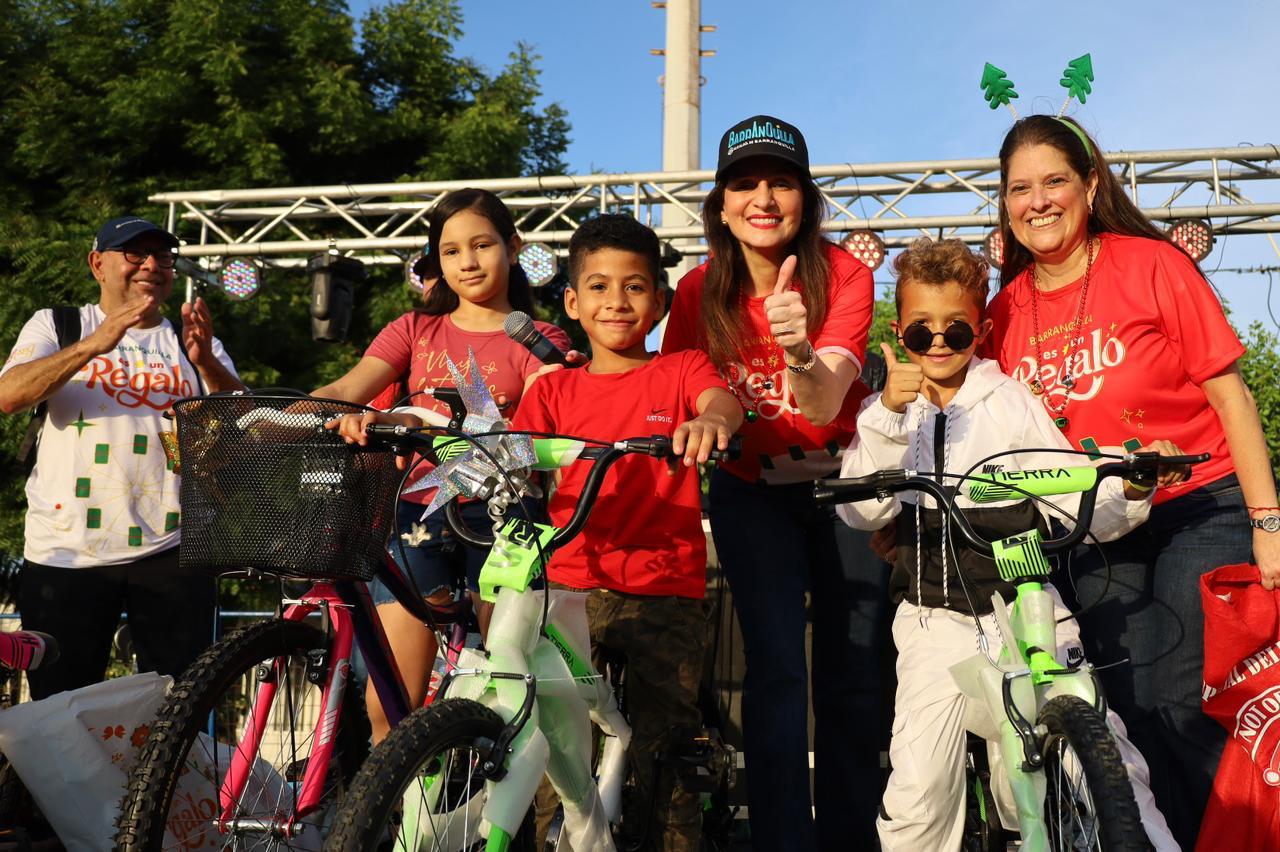 La primera dama junto a gerente social entregando regalos en la novenas navideñas