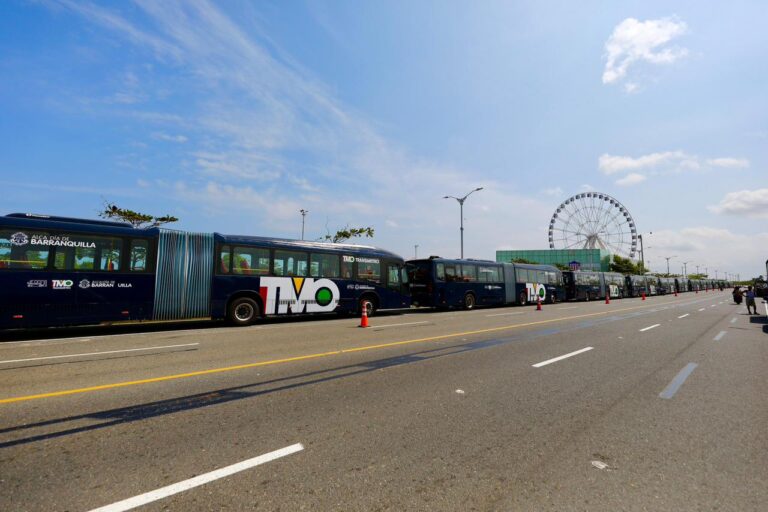 Fila de buses de transmetro alineados uno tras otro en el carril derecho ubicados en el Gran malecón y atrás se observa la Luna del Rio