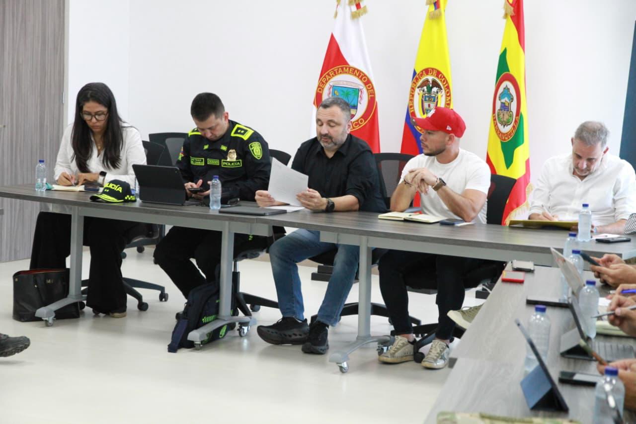 Reunión con directivos y la Policía están sentadas alrededor de mesas rectangulares, cada una con laptops, cuadernos.