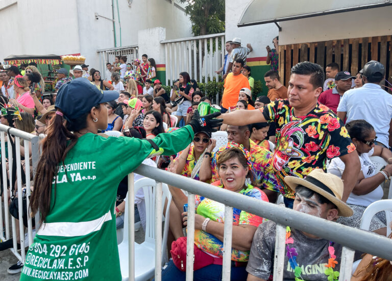 Trabajadora de aseo recogiendo recipiente en lata