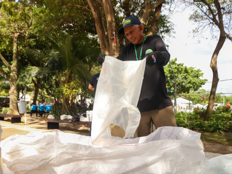 persona realizando labores de aseo y recolección de residuos en un parque